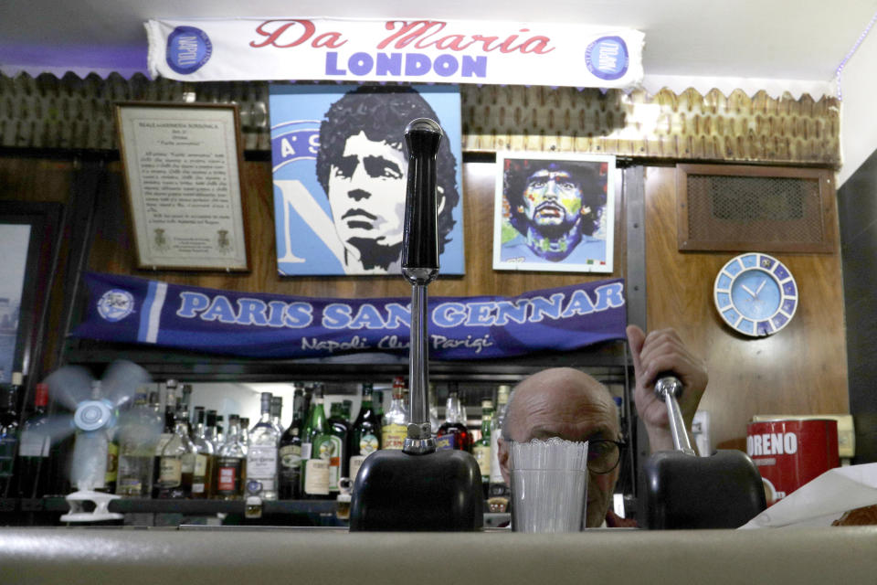 FILE - A bartender prepares an espresso coffee inside the Bar Nilo where a makeshift shrine of soccer legend and former Napoli player Diego Armando Maradona is displayed, in downtown Naples, Italy, Sept. 18, 2019. The legend of Diego Maradona at Napoli hovers over the current team’s Italian league title, which was sealed Thursday, May 4, 2023. The Argentina standout holds saint-like status in Naples 2 ½ years after his death and more than three decades after he led Napoli to its first two Serie A titles. (AP Photo/Gregorio Borgia, File)