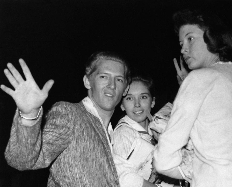 Jerry Lewis, left, waves goodbye with his wife, Myra Lewis and his sister, Frankie Lewis, right, as they board an airliner, in London, May 27, 1958. Lewis is leaving England following tours cancelled by the Rank Organisation and Granada Cinemas following reports of his marriage to his 13-year-old cousin while still married to his second wife.  (AP Photo)