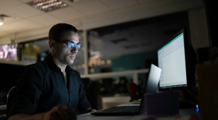 Trader sit in front of his computer working late at night 