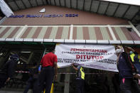 City hall officials put up a banner at a locked down wet market as one of its traders tested positive for COVID-19 in Petaling Jaya, Malaysia, Tuesday, April 28, 2020. The Malaysian government issued a restricted movement order to the public till April 28, to help curb the spread of the new coronavirus. (AP Photo/Vincent Thian)