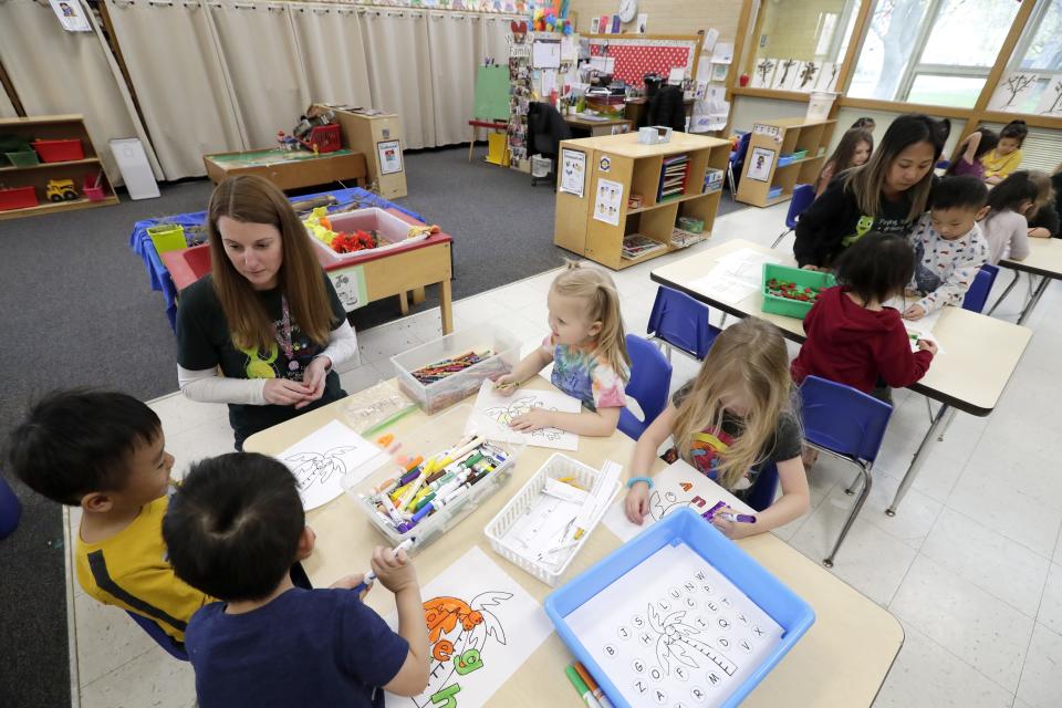 Paraprofessional Tami Webb, upper left, works on an activity with 4K students at Foster Elementary School.