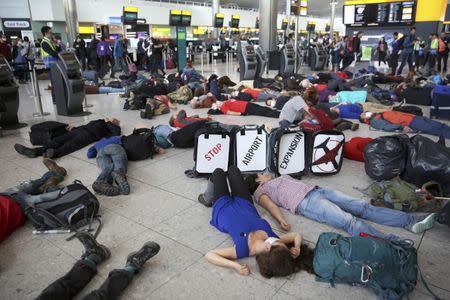 Climate activist group Reclaim the Power lie on the ground and carry luggage during a protest against airport expansion plans at Heathrow Airport in London, Britain October 1, 2016. REUTERS/Neil Hall