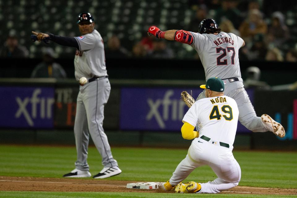 Cleveland Guardians catcher Austin Hedges (27) knocks the ball out of the glove of Athletics first baseman Ryan Noda as Noda tried to apply a tag during the fourth inning, March 28, 2024, in Oakland.