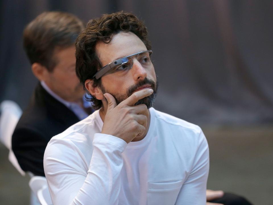 Sergey Brin wearing Google Glass with hand on chin