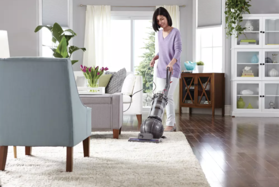 Photo of a woman vacuuming the rug in her living room