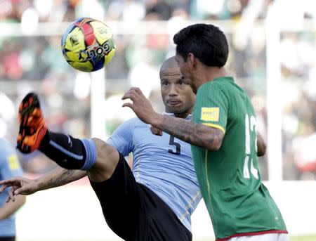 Carlos Sanchez (L) of Uruguay battles for the ball with Jair Torrico of Bolivia during their 2018 World Cup qualifying soccer match at the Hernando Siles Stadium in La Paz, Bolivia October 8, 2015. REUTERS/David Mercado