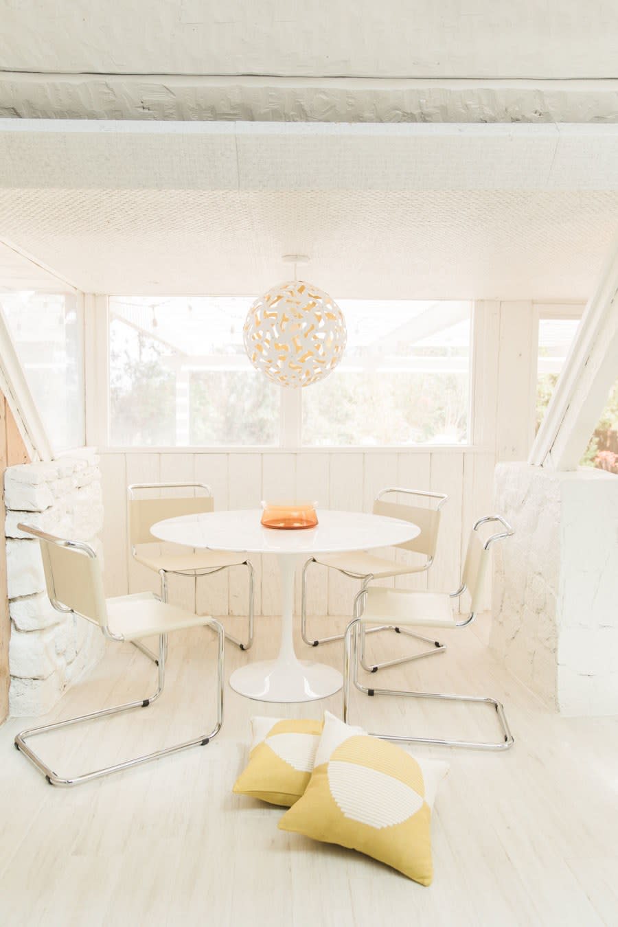 The bright white dining room was designed with Anne Sage. Here again, that pop of yellow.