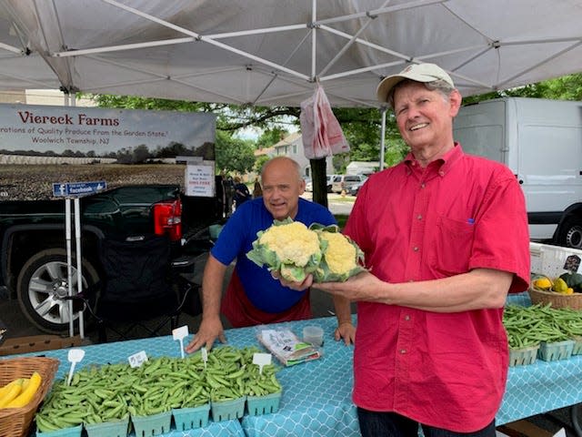 Collingswood Farmers Market manager David Hodges displays cauliflower heads at the market's  Viereck Farms stand.