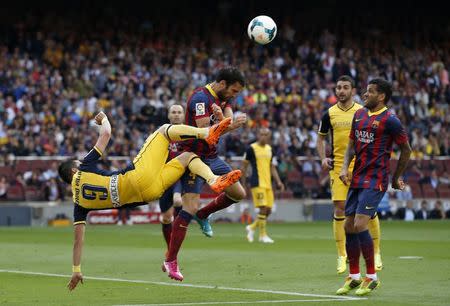 Atletico Madrid's David Villa (L) challenges Barcelona's Cesc Fabregas during their Spanish first division soccer match at Camp Nou stadium in Barcelona May 17, 2014. REUTERS/Marcelo del Pozo