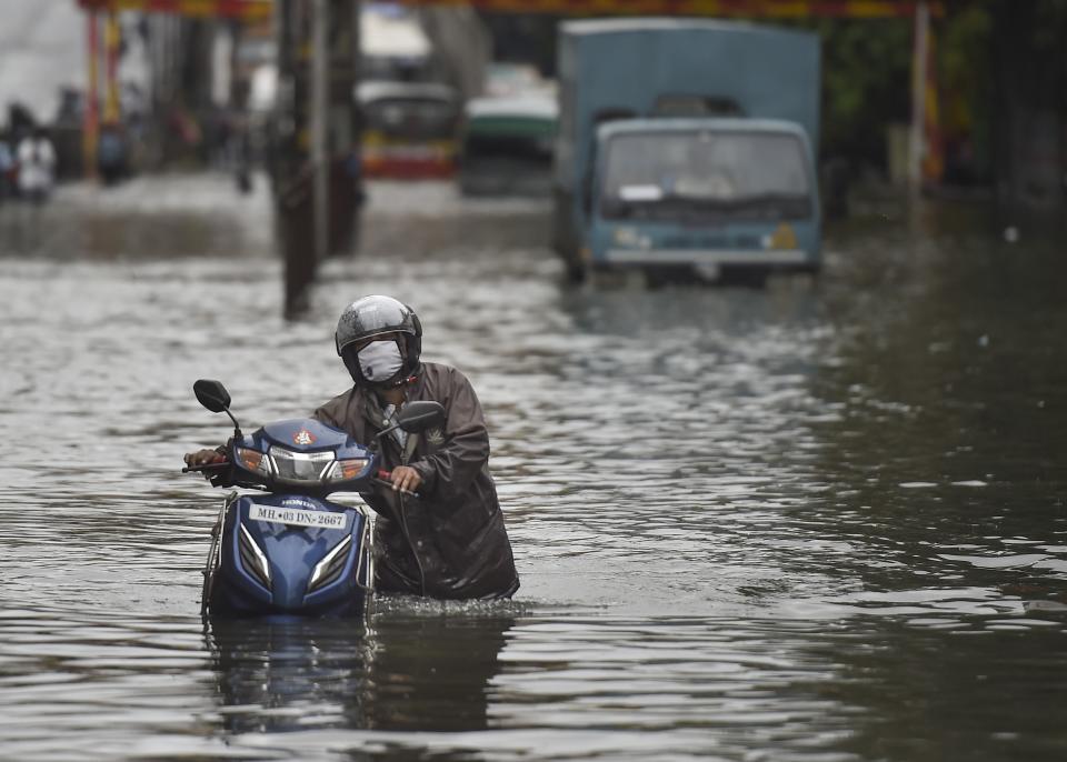 Mumbai: A commuter wades through a waterlogged street after heavy monsoon rain, at Sion in Mumbai, Wednesday, Sept. 23, 2020. (PTI Photo/Kunal Patil)(PTI23-09-2020_000075A)