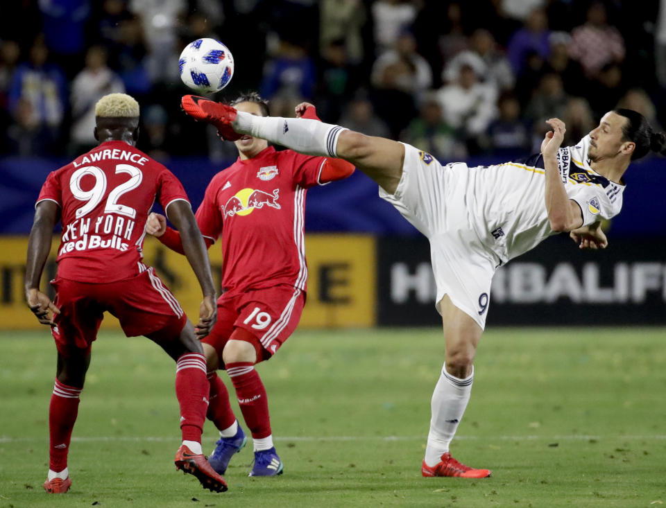 FILE -LA Galaxy forward Zlatan Ibrahimovic, right, kicks the ball past New York Red Bulls' Kemar Lawrence, left, and Alex Muyl during the second half of an MLS soccer match Saturday, April 28, 2018 in Carson, Calif. Zlatan Ibrahimović was in MLS for only two seasons with the LA Galaxy, but they were two spectacularly memorable seasons filled with cockiness, showmanship, panache, and some spectacular goals. (AP Photo/Chris Carlson, File)