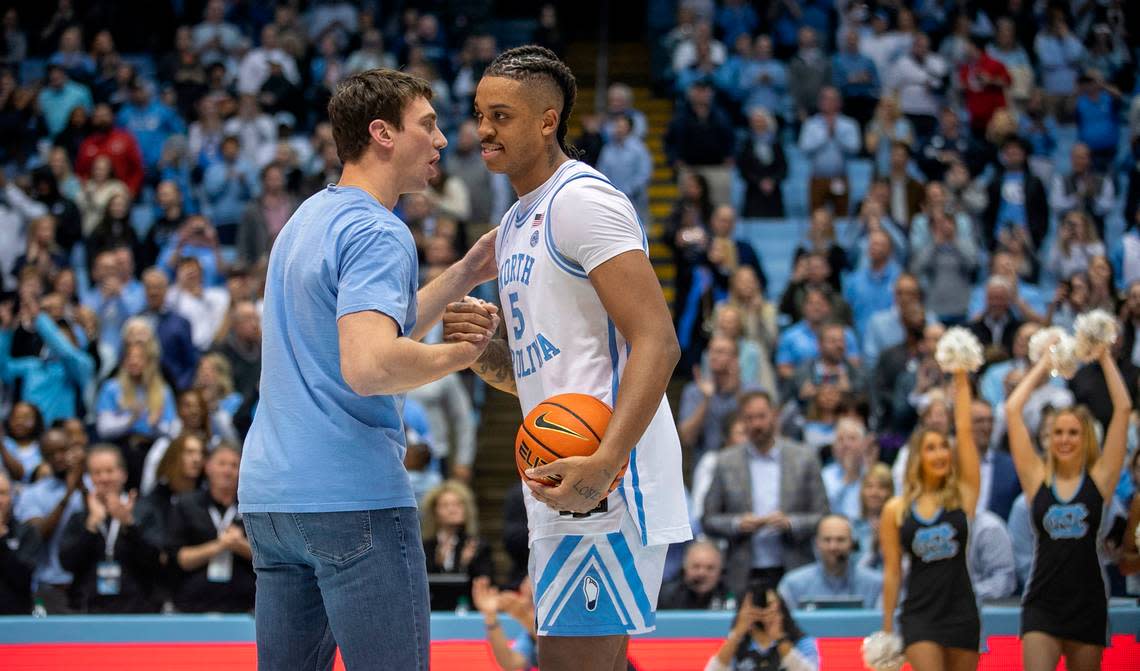 Tyler Hansbrough congratulates North Carolina’s Armando Bacot (5), presenting him the game ball after he set a new record for rebounds with 1,220 passing Hansbrough’s record in 2009, following the Tar Heels’ 80-69 victory over N.C. State on Saturday, January 21, 2023 at the Smith Center in Chapel Hill, N.C.