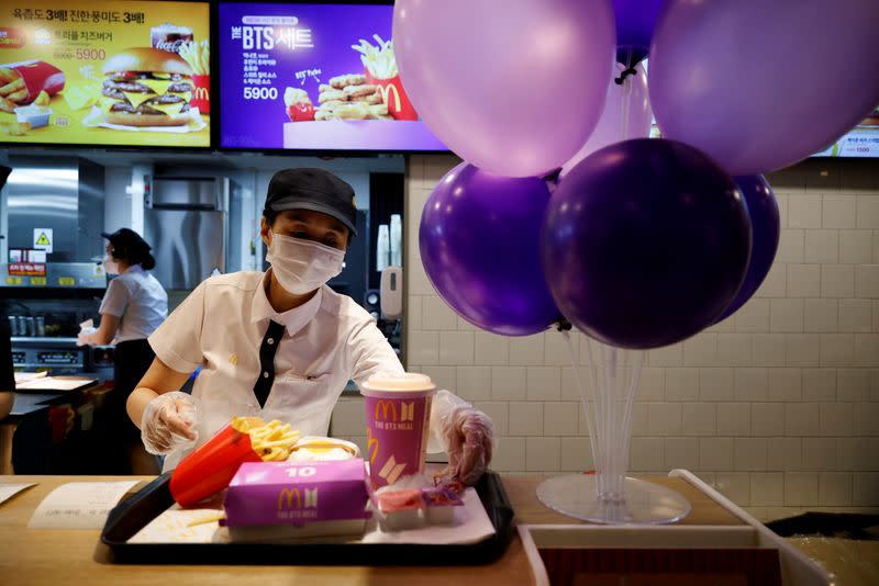 FILE PHOTO: An employee of McDonald's serves a BTS meal, which is inspired and promoted by K-pop boy band BTS, during lunch hour at its restaurant in Seoul