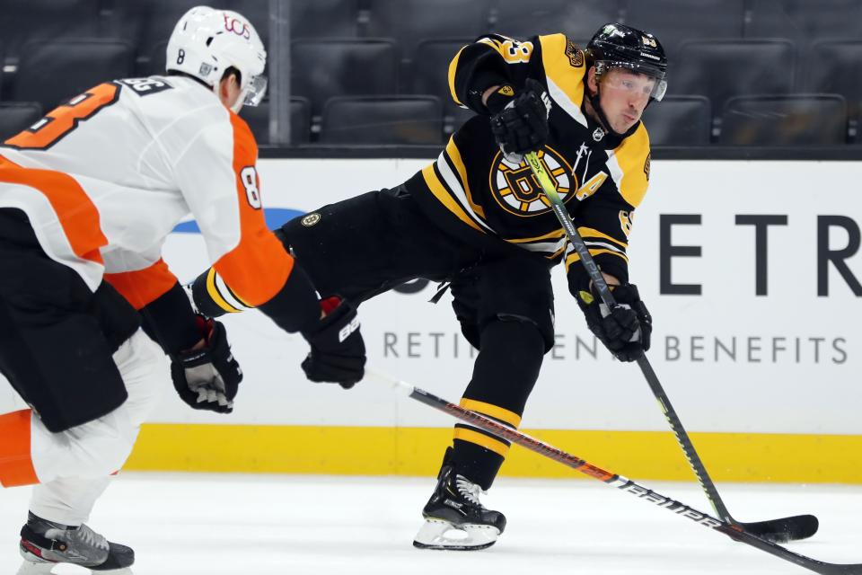 Boston Bruins' Brad Marchand (63) takes a shot against Philadelphia Flyers' Robert Hagg (8) during the second period of an NHL hockey game, Saturday, Jan. 23, 2021, in Boston. (AP Photo/Michael Dwyer)