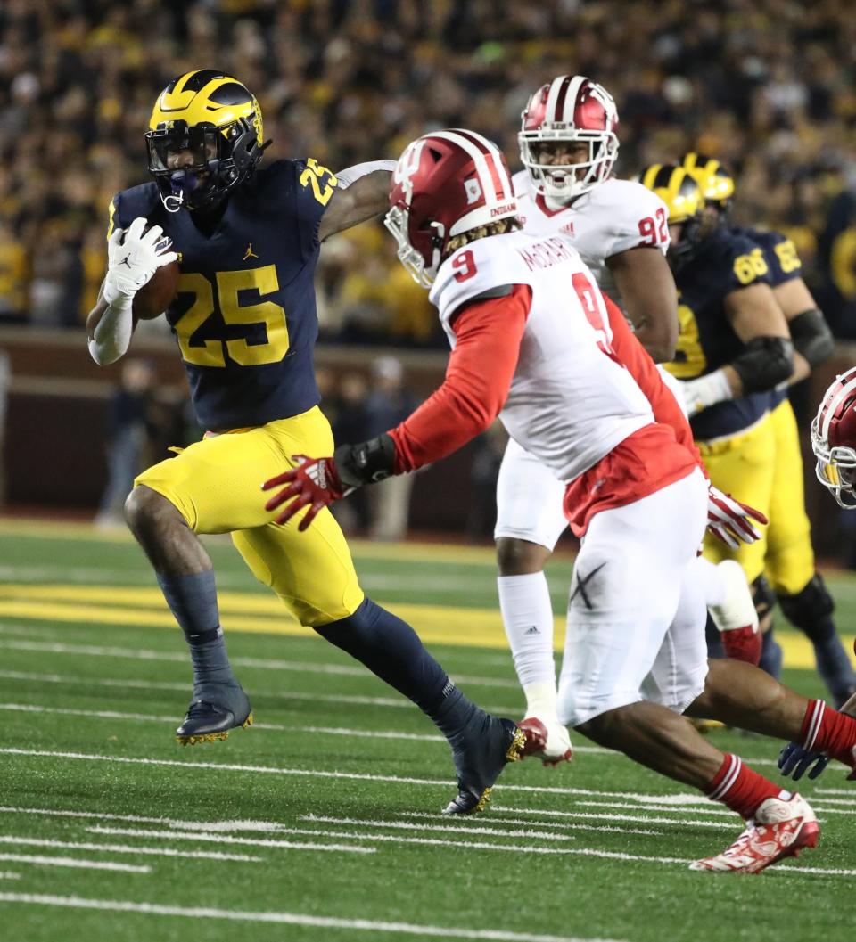 Michigan running back Hassan Haskins runs by Indiana defensive back Marcelino McCrary-Ball during the first half on Saturday, Nov. 6, 2021, at Michigan Stadium.