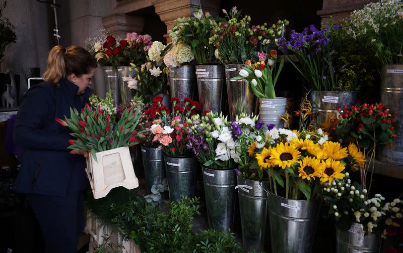 Head florist Anna Molicka adds a container of tulips to the display in the Giraffe Flowers florist shop in Manchester