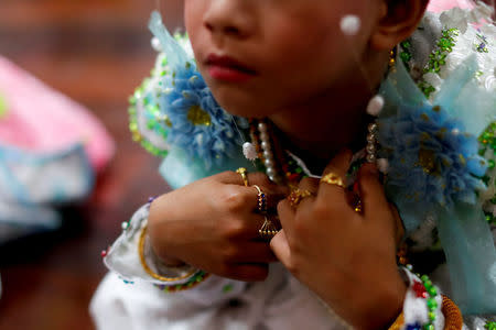 A boy waits inside Wat Klang Thung temple in preparation for an annual Poy Sang Long procession, part of the traditional rite of passage for boys to be initiated as Buddhist novices, in Mae Hong Son, Thailand, April 3, 2018. REUTERS/Jorge Silva