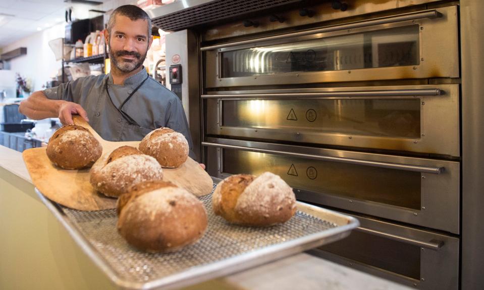 Josué Santiago Negrón, owner and chef of Dulce Artisanal Pastry, displays freshly made  loaves of fig and hazelnut bread in his Collingswood bakery.