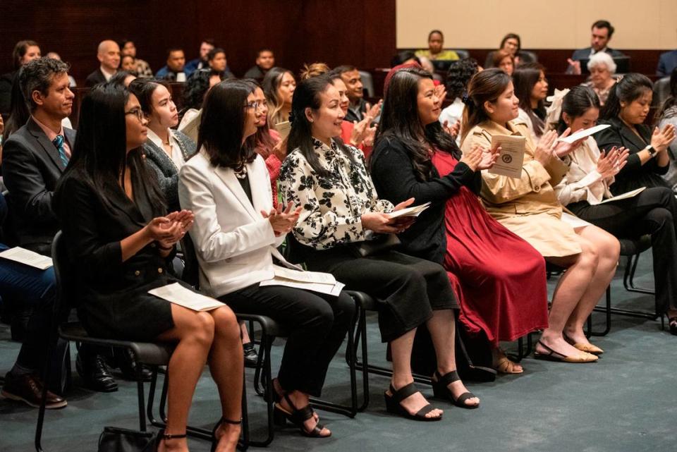 Newly naturalized American citizens clap during a naturalization ceremony at Dan M. Russell Courthouse in Gulfport on Thursday, Oct. 19, 2023.