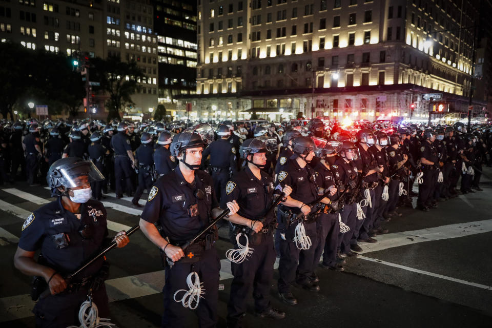 FILE — In his June 4, 2020 file photo, New York City Police Department officers stand in formation after arresting multiple protesters marching after curfew on Fifth Avenue, in New York, following the death of George Floyd, in Minneapolis. The New York Police Department was caught off guard by the size and scope of the spring protests sparked by the police killing of George Floyd in Minneapolis and resorted to disorder control tactics that stoked tensions and stifled free speech rights, the city's inspector general said in a report released Friday, Dec. 18, 2020. (AP Photo/John Minchillo, File)