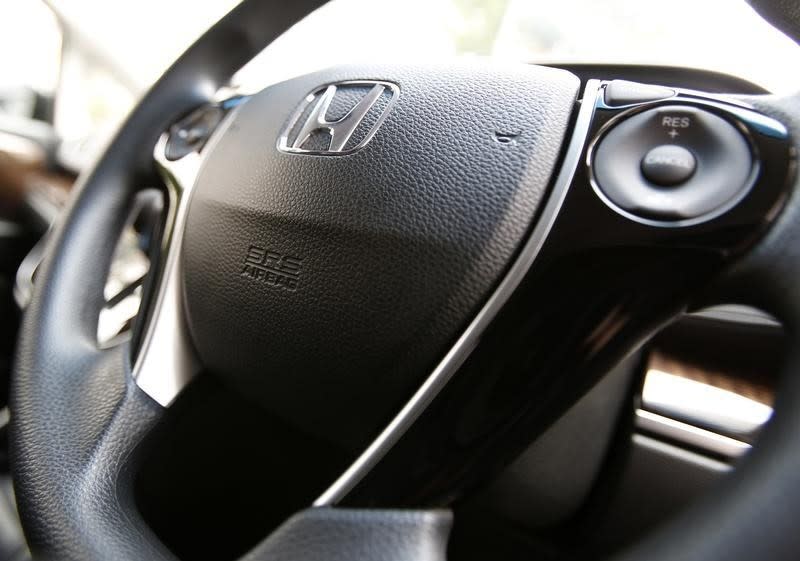 The logo of Honda Motor Co and an airbag logo are seen on a steering wheel of a car displayed at the company's showroom in Tokyo June 17, 2014. REUTERS/Yuya Shino