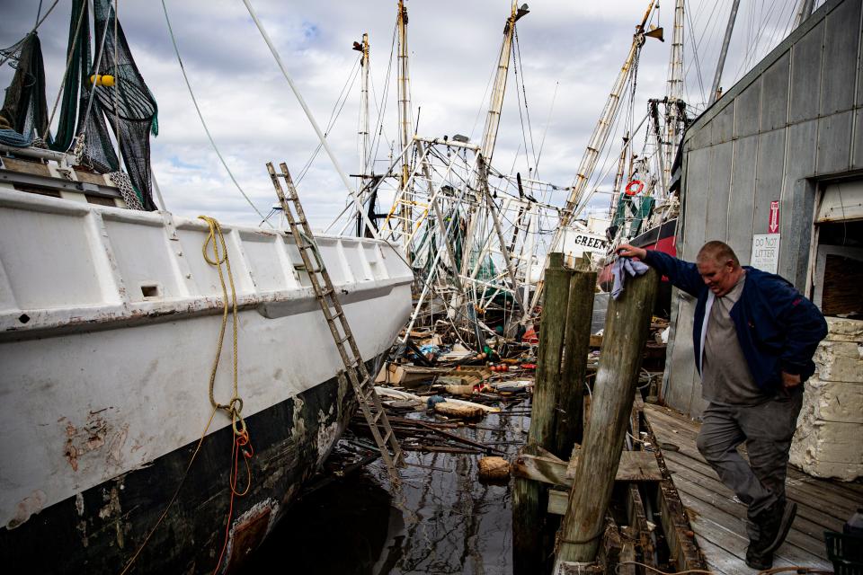 Jesse Clapham, the shrimp boat fleet manager for Erickson & Jensen Shrimp Packers on Fort Myers Beach, pauses while working on a Hurricane Ian damaged shrimp boat on Oct. 20, 2022. The shrimping industry was severely impacted by Hurricane Ian. Most of the fleet was washed onto land by the storm surge.