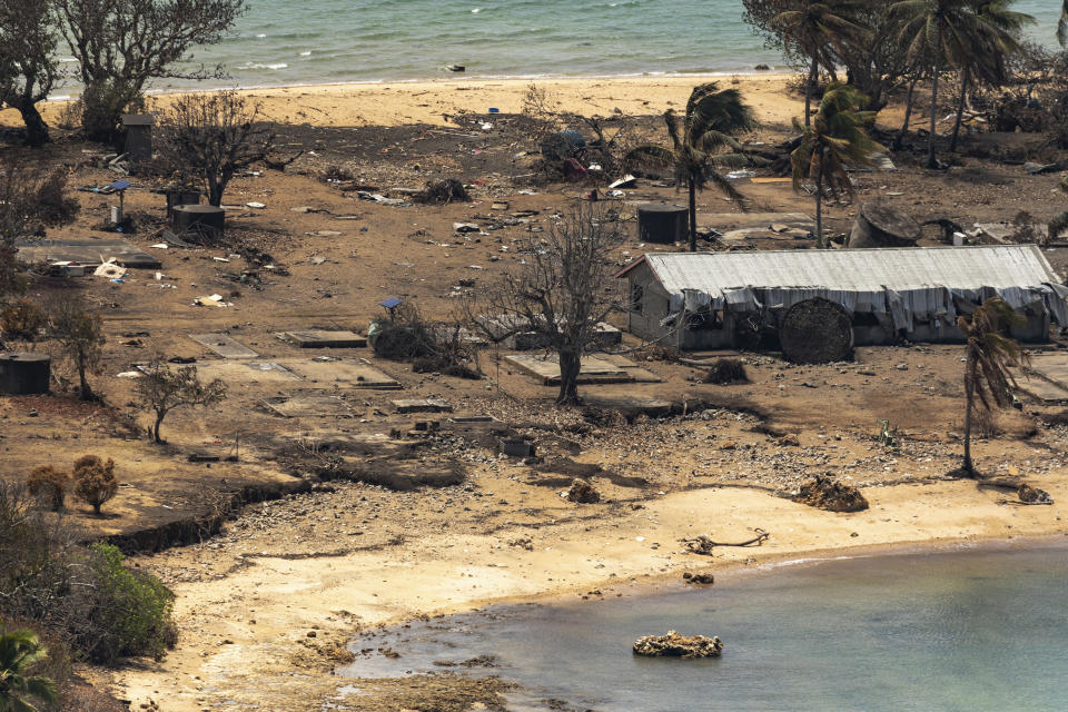 In this photo provided by the Australian Defence Force debris from damaged building and trees is strewn around on Atata Island in Tonga, Jan. 28, 2022, following the eruption of an underwater volcano and subsequent tsunami. The international aid Tonga accepted after the disaster has caused the country's first COVID-19 outbreak, and there are worries the isolation that kept Tonga and other Pacific nations virus-free until now will hurt their ability to manage the public health threat.(POIS Christopher Szumlanski/Australian Defence Force via AP)