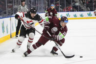 Canada's Elliot Desnoyers (19) and Latvia's Ralfs Bergmanis (16) battle for the puck during the second period of an IIHF junior world hockey championships game Wednesday, Aug. 10, 2022, in Edmonton, Alberta. (Jason Franson/The Canadian Press)