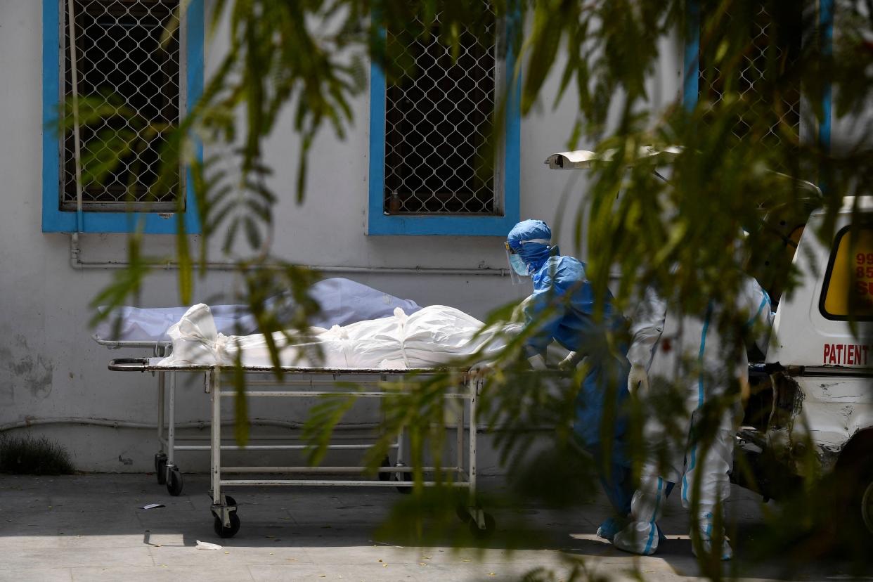 <p>Representative: A medical staff prepares to transfer the body of a patient who died of the Covid-19 coronavirus disease into an ambulance at a mortuary in New Delhi on 29 April 2021</p> (Getty Images)