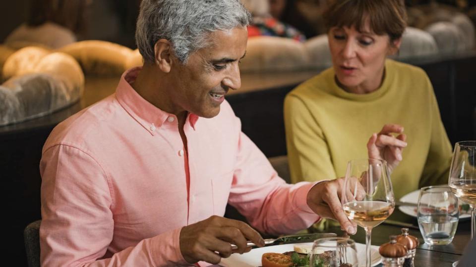 Mature couple in a discussion while eating a meal in a restaurant.