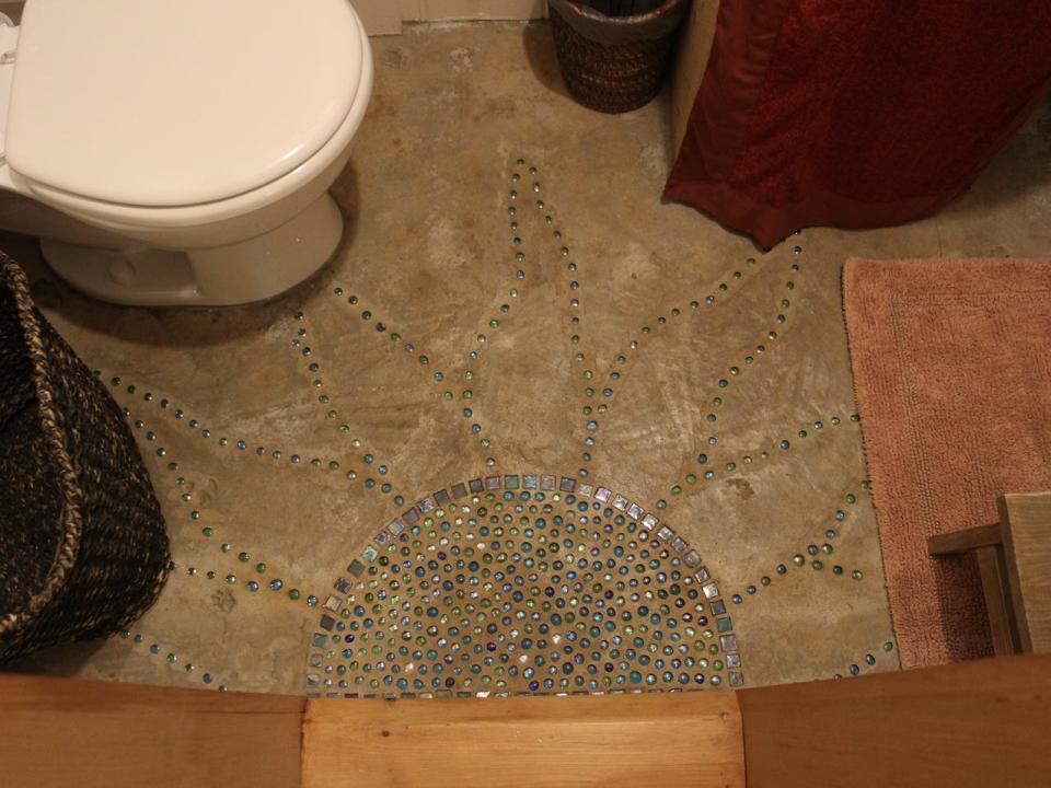 a sun mosaic in the bathroom of the tiny house
