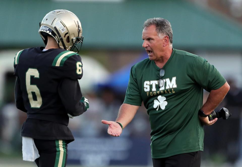 STVM football coach Terry Cistone congratulates the defense after a pick six against Buchtel on Sept. 9, 2022, in Akron.