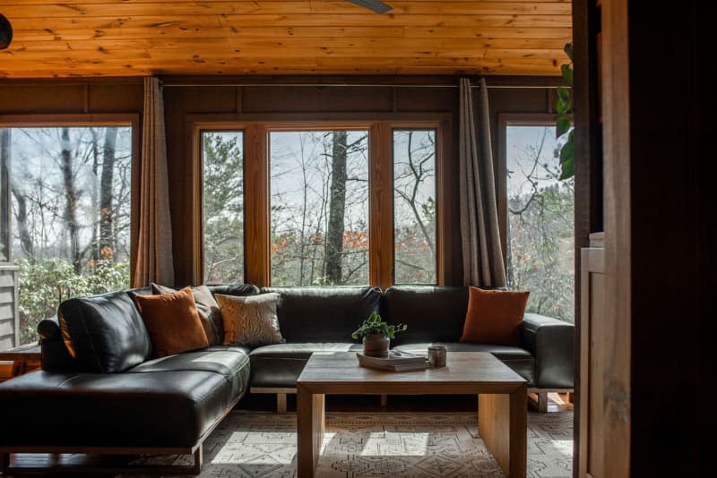 A large L shaped leather couch in a brown living room.