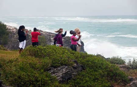 People stand on the island's south shore to feel the winds from approaching Hurricane Gonzalo, in Astwood Park, October 17, 2014. REUTERS/Nicola Muirhead