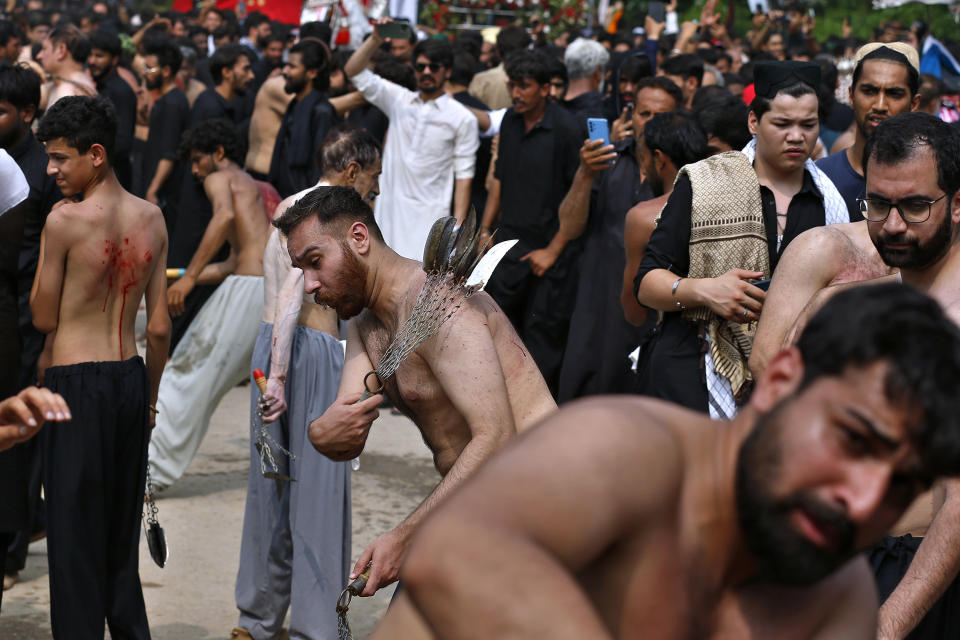 Shiite Muslims flagellate themselves with knives on chains during a Muharram procession, in Islamabad, Pakistan, Monday, Aug. 8, 2022. Muharram, the first month of the Islamic calendar, is a month of mourning for Shiites in remembrance of the death of Hussein, the grandson of the Prophet Muhammad, at the Battle of Karbala in present-day Iraq in the 7th century. (AP Photo/Anjum Naveed)