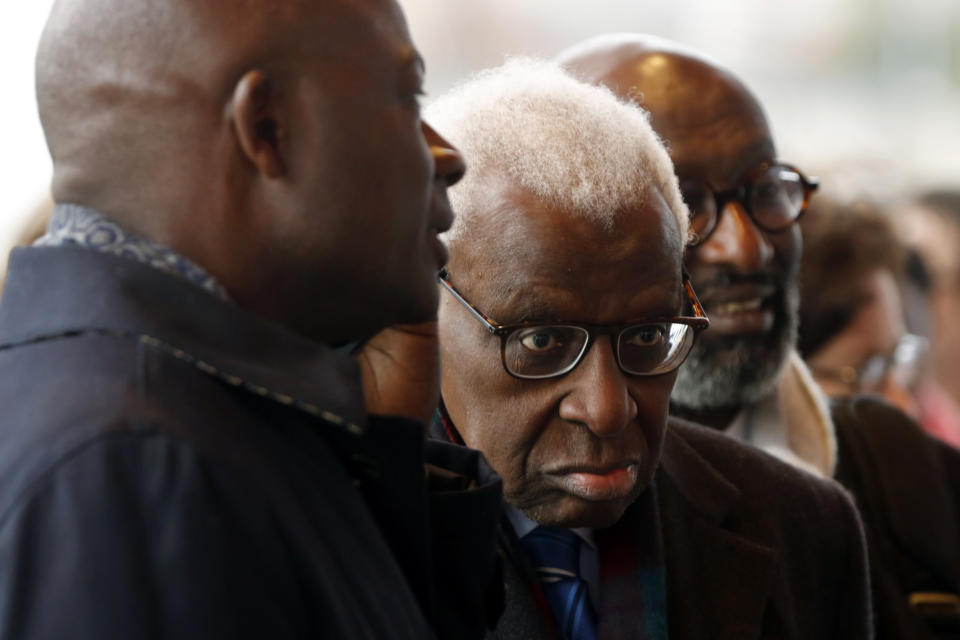 CAPTION CORRECTS SPELLING OF SURNAME Former president of the IAAF (International Association of Athletics Federations) Lamine Diack, center, arrives at the Paris courthouse, Monday, Jan. 13, 2020. One of the biggest sports corruption cases to reach court is being heard in Paris from Monday, with explosive allegations of a massive doping cover-up at the top of track and field. (AP Photo/Thibault Camus)