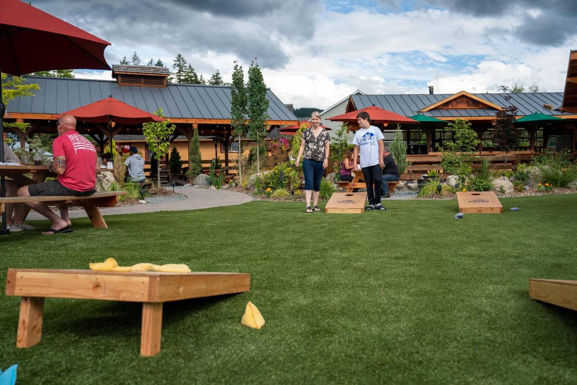 Donna Ragazzo and her son Jarin play corn hole on the outside lawn at Mill Haus Cider Co. on Thursday July 7, 2022. Clare Grant/cgrant@thenewstribune.com