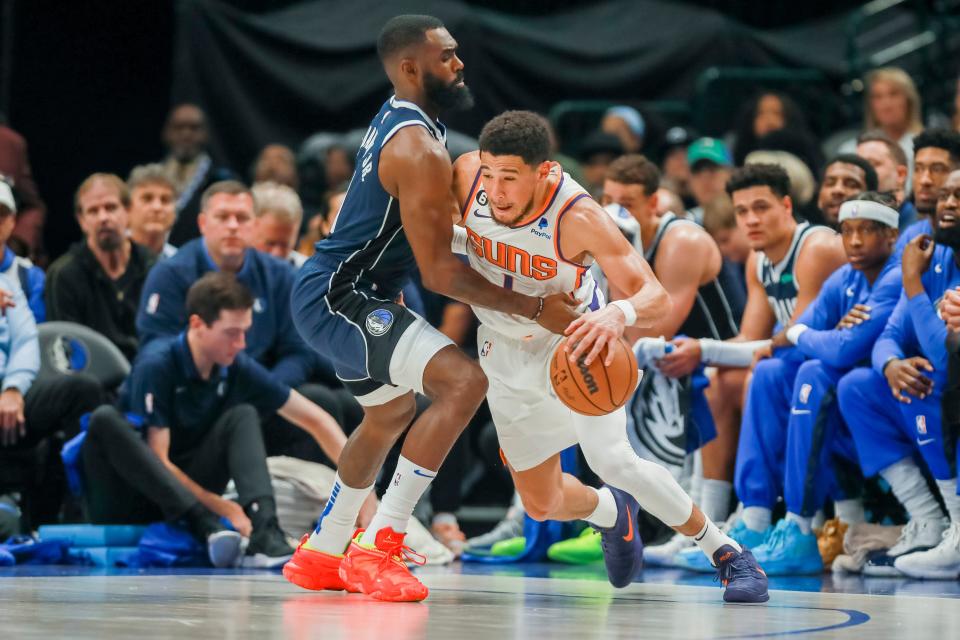 Phoenix Suns guard Devin Booker, right, drives to the basket as Dallas Mavericks forward Tim Hardaway Jr, left, defends during the first half of an NBA basketball game, on March 5, 2023, in Dallas.