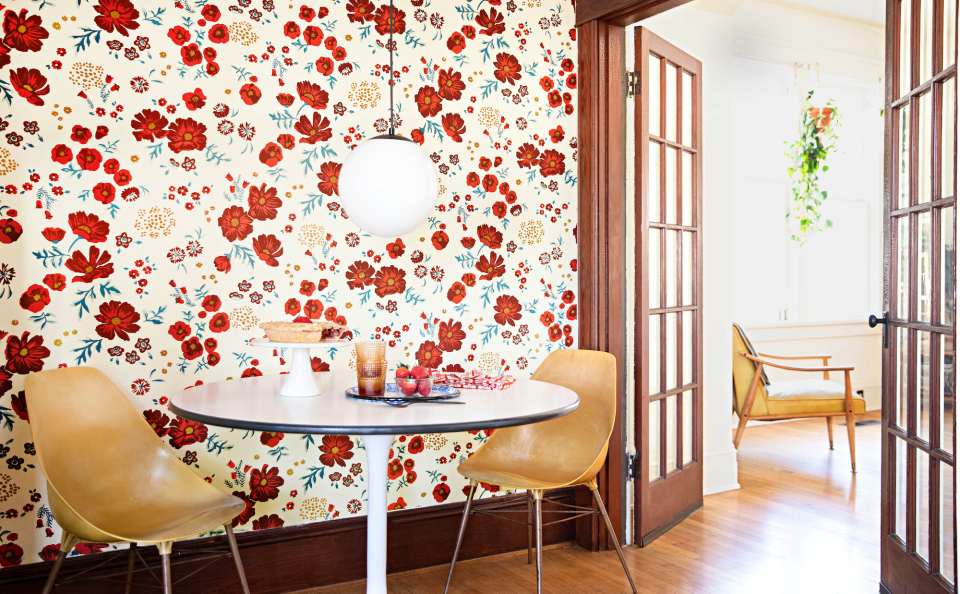 red floral wallpaper and midcentury furniture in dining area