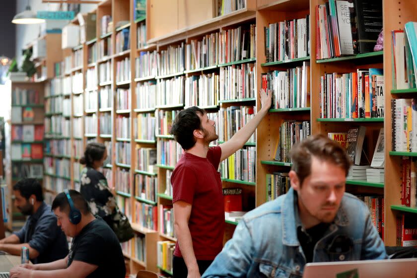 Los Angeles, CA - March 11: Gleb Wilson, center, views books at Stories Books and Cafe in Los Angeles Friday, March 11, 2022. (Allen J. Schaben / Los Angeles Times)