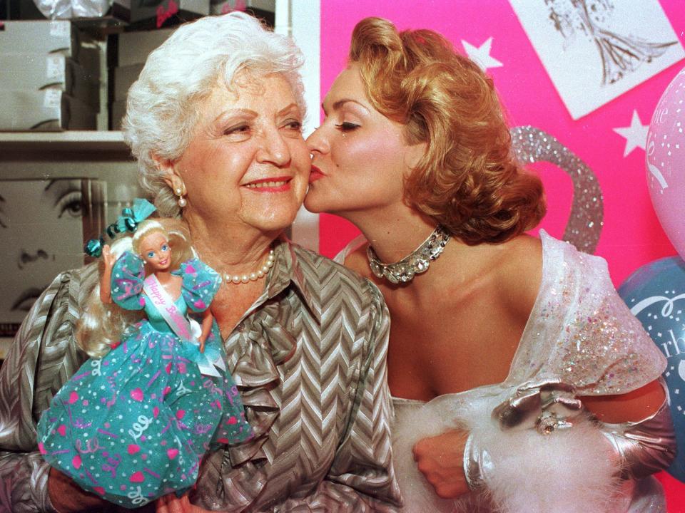 Ruth Handler is kissed by actress Kristi Cooke who is dressed as a Barbie Doll during the 35-year anniversary of the doll in New York City in 1994.