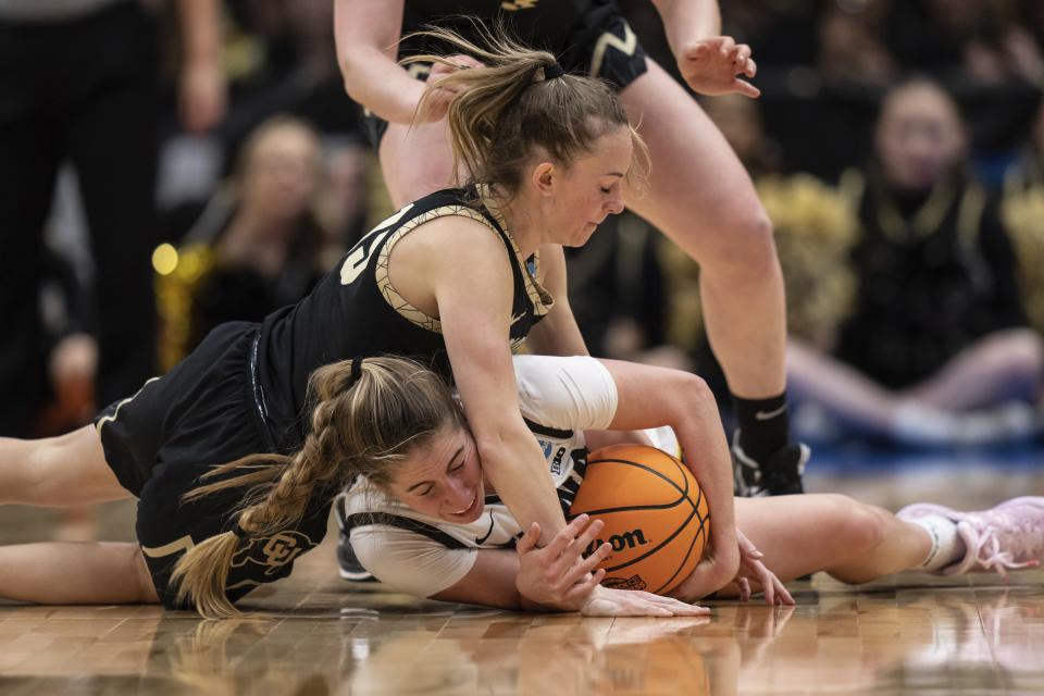 Colorado guard Kindyll Wetta, top, and Iowa guard Kate Martin vie for the ball during the first half of a Sweet 16 college basketball game in the women's NCAA tournament Friday, March 24, 2023, in Seattle. (AP Photo/Stephen Brashear)