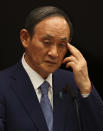 Japan's Prime Minister Yoshihide Suga attends a news conference on Japan's response to the coronavirus pandemic during the Tokyo 2020 Olympic Games in Tokyo, Japan, Friday, July 30, 2021. Suga expanded a coronavirus state of emergency to four more areas in addition to Tokyo on Friday following record spikes in infections as the capital hosts the Olympics. (Issei Kato/Pool Photo via AP)