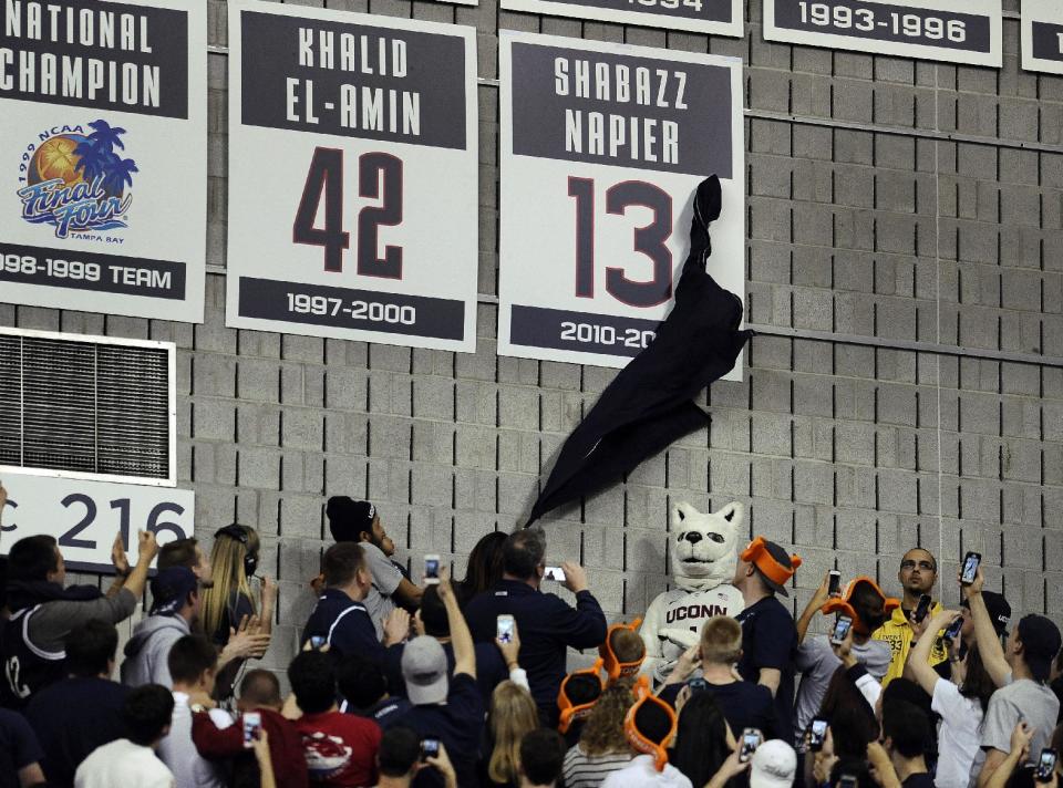 Carmen Velasquez, mother of Connecticut's Shabazz Napier, unveils her son's number on the Huskies Wall of Honor at a pep rally celebrating the the men's basketball team's NCAA championship, Tuesday, April 8, 2014, in Storrs, Conn. (AP Photo/Jessica Hill)