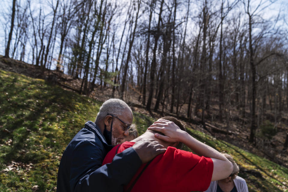 Quick Response Team member pastor Fred McCarty, prays with a young man who recently overdosed as they visit him at his home in Barboursville, W.Va., Thursday, March 18, 2021. McCarty is one of the faith leaders who ride with the team. When they reach people who overdosed, he asks if they'd like him to pray with them, and usually they say yes. On his keychain he carries the coin he got in 1985, when he finished treatment for his own alcohol addiction. It says "one day at a time," and it's worn down from rubbing his finger across it for more than 30 years. "Recovery is about sharing your strengths and hopes with others," he said. "Our hope is that a lightbulb will come on. And they'll say, if you can do it, I can do it." (AP Photo/David Goldman)