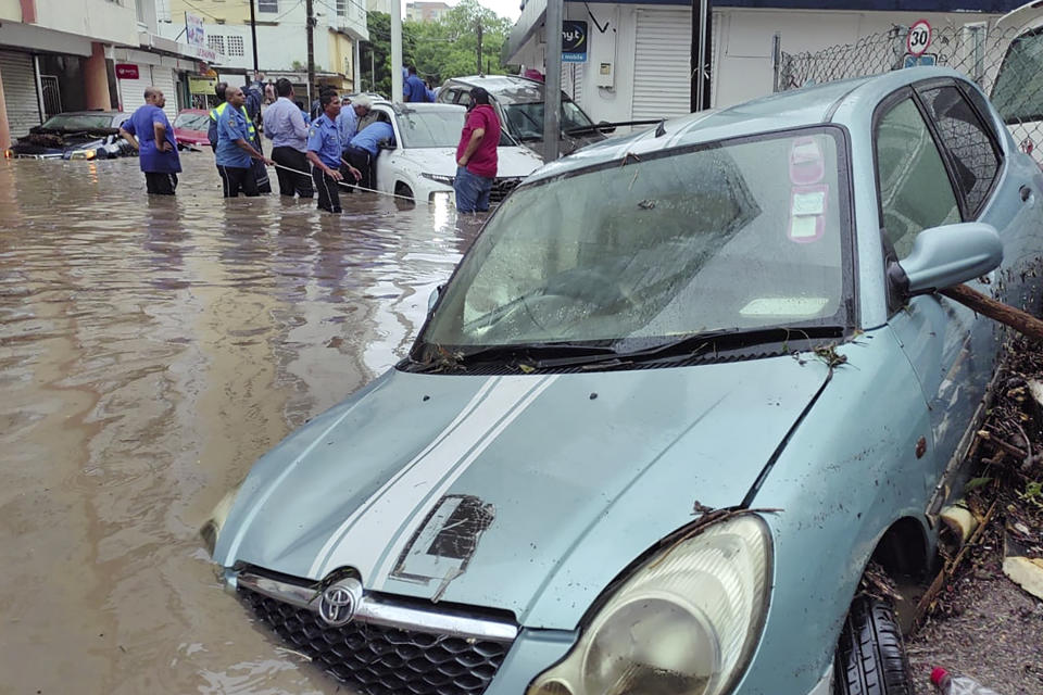 A car partially submerged in the floodwaters caused by the cyclone is washed up on the side of a road in Port Louis, the capital city of Mauritius, Tueday Jan. 16, 2024. Mauritius lifted its highest weather alert and eased a nationwide curfew Tuesday after a cyclone battered the Indian Ocean island, causing heavy flooding and extensive damage in the capital city and other parts of the country. (Lexpress.mu via AP)