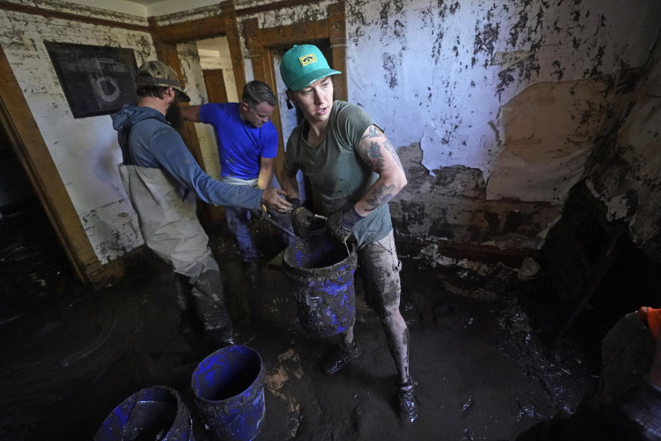 FILE - Volunteers clean out a flooded basement on June 16, 2022, in in Red Lodge, Mont. Yellowstone National Park is reopening its flood-damaged north loop at noon on Saturday, July 2, 2022, in time for the Fourth of July holiday weekend. Park officials say the roads from Norris Junction to Mammoth Hot Springs, to Tower-Roosevelt, to Canyon Junction and back to Norris Junction will be open. The loop is reopening nearly three weeks after massive flooding forced thousands to flee the park as water, rocks and mud washed out bridges and roads. (AP Photo/Rick Bowmer, File)