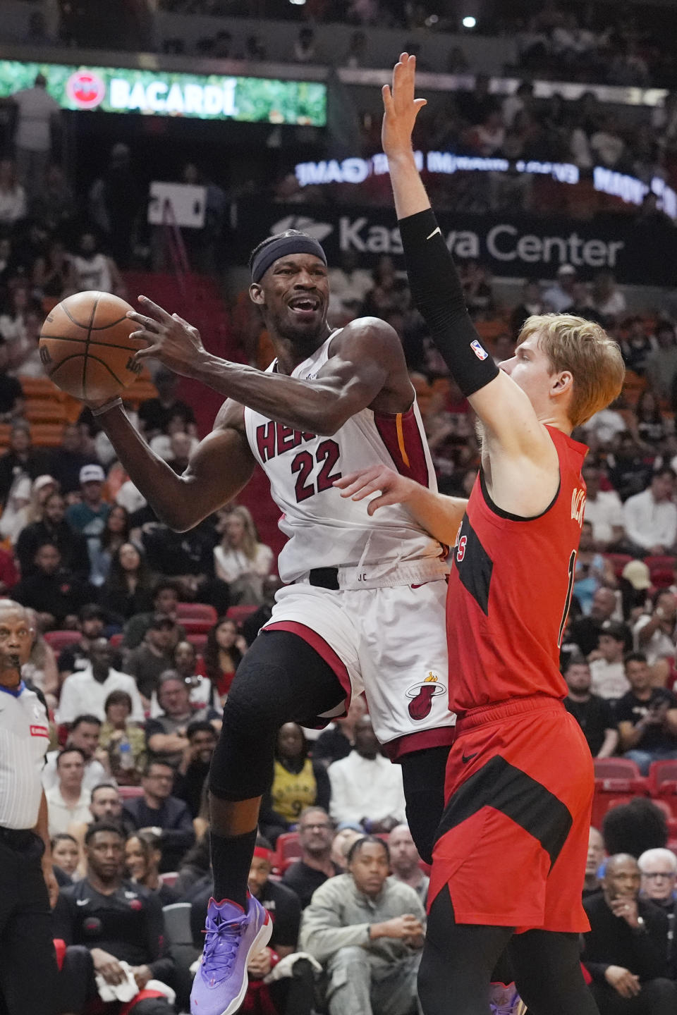 Miami Heat forward Jimmy Butler (22) aims to pass the ball as Toronto Raptors guard Gradey Dick (1) defends during the first half of an NBA basketball game, Friday, April 12, 2024, in Miami. (AP Photo/Marta Lavandier)