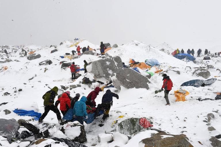 Sherpas and climbers help carry a person injured by an avalanche that flattened part of Everest Base Camp, on April 25, 2015