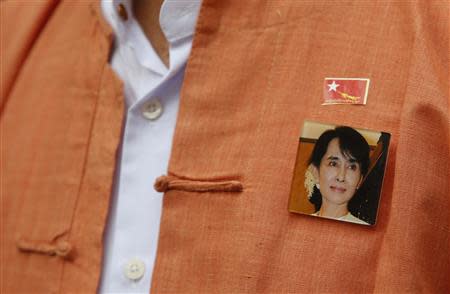 A man wearing a sticker of the National League for Democracy (NLD) party emblem and a badge of Myanmar's opposition leader Aung San Suu Kyi, arrives to meet Suu Kyi on the island of Sentosa in Singapore September 22, 2013. REUTERS/Edgar Su